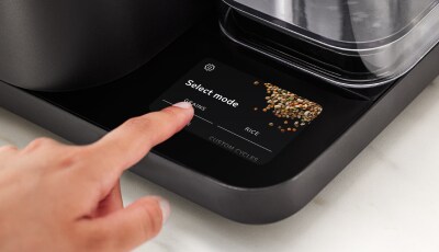 A person selecting a cycle on the touchscreen of the Grain and Rice Cooker.