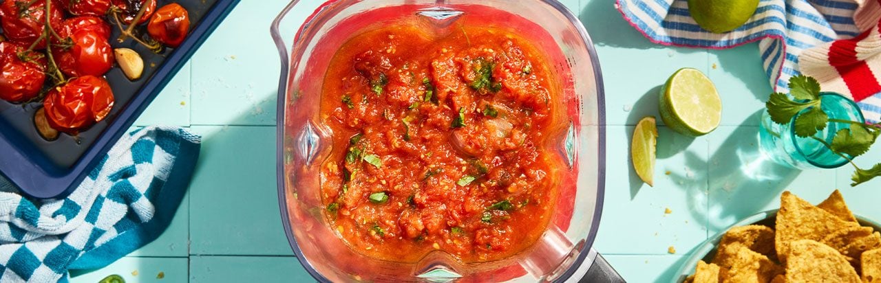 A scone on a napkin with a small container of herb butter. 