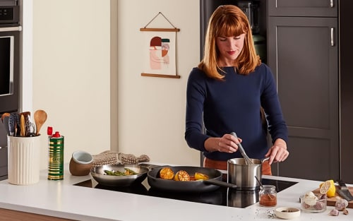 Person stirring food in sauce pan on an induction stovetop