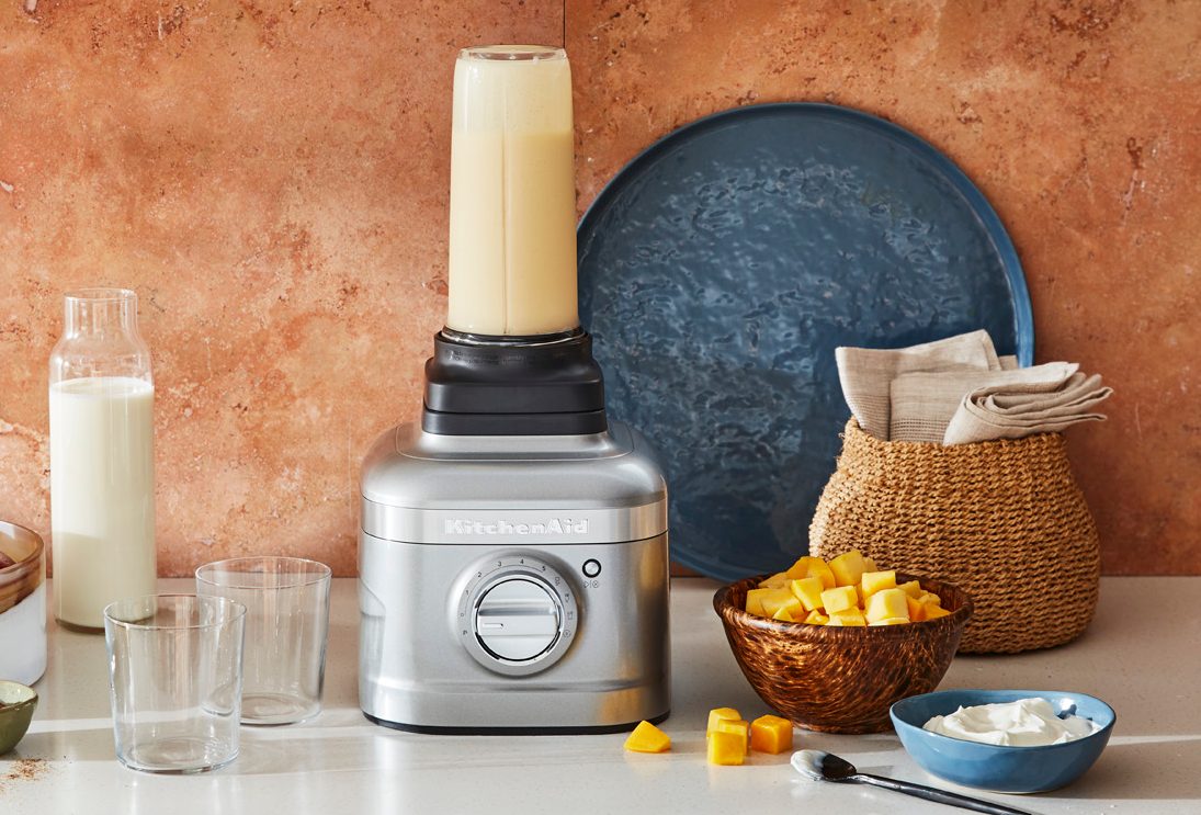 Mélangeur KitchenAid K400 avec pichet individuel fixé au mélangeur à côté de bols d'ingrédients prêts à être mélangés