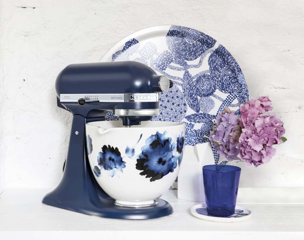 Batteur sur socle bleu avec découpeur en spirale et courgettes étant coupées en spirale