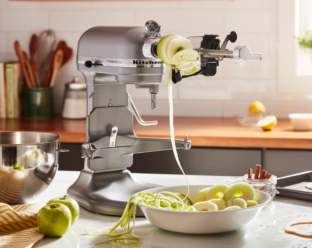 Batteur sur socle KitchenAid Pro 600 argent contour avec découpeur en spirale et une pomme étant évidée et coupée en spirale.