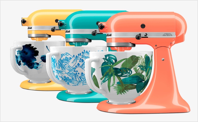 3 batteurs sur socle KitchenAid de couleur bouton d’or, bleu glacier et oiseau de paradis avec bols en céramique fleuris