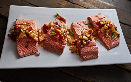 Seasoned salmon before being cooked using the sous vide method on a rustic table
