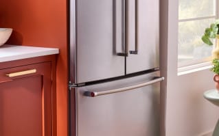 Réfrigérateur à portes françaises KitchenAid® à côté d'armoires couleur terre cuite