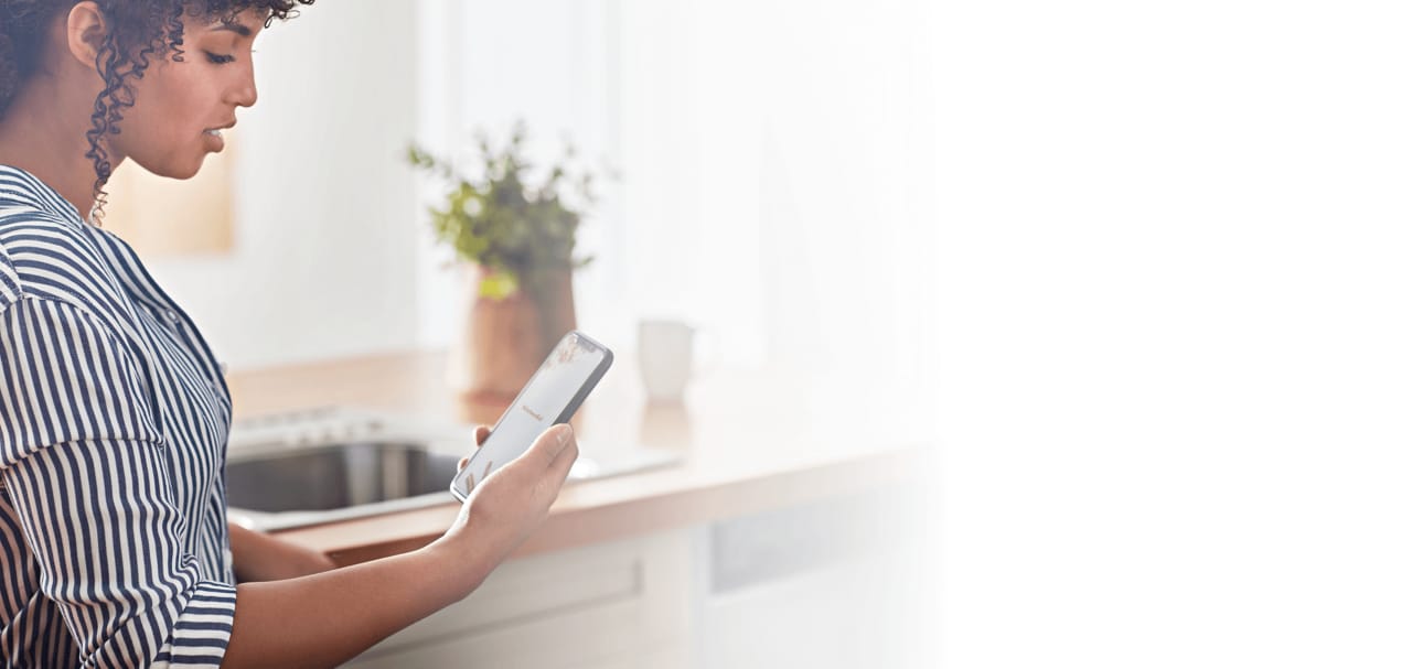 Jeune femme se familiarisant avec sa nouvelle application KitchenAid™.