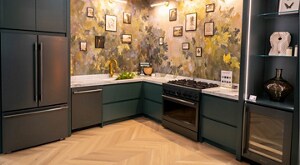 A kitchen with a host of KitchenAid appliances: a refrigerator, dishwasher, range, and beverage centre. Framed photos hang on the wall. A KitchenAid stand mixer is on the counter. 