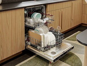 A kitchen with an island filled with bowls and plates of food. Also in the kitchen is a KitchenAid oven and over-the-range microwave and a KitchenAid refrigerator.
