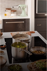 Three pans cooking on an induction cooktop