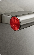 A close up of the red medallions on the ends of a stainless steel handle.