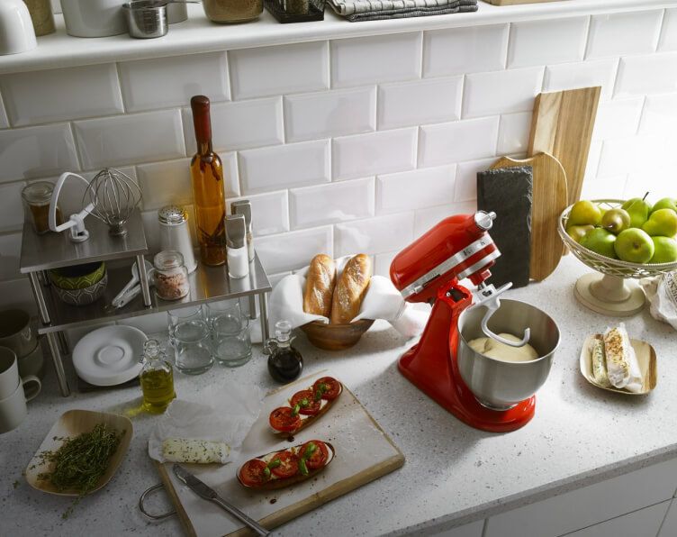 Red Stand Mixer with dough hook attached, and stainless steel bowl with dough in it.